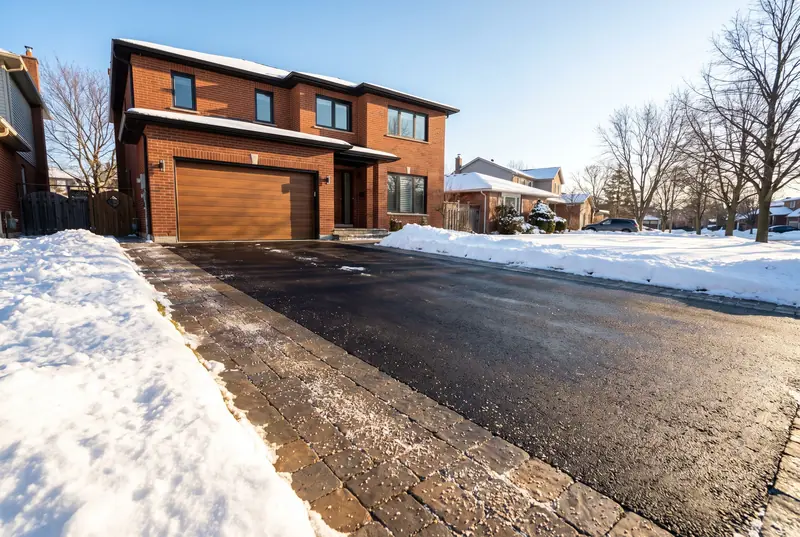 A freshly cleared driveway and walkway on a sunny morning