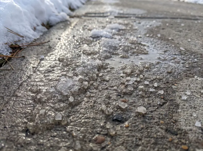 Salt crystals on a melting icy walkway