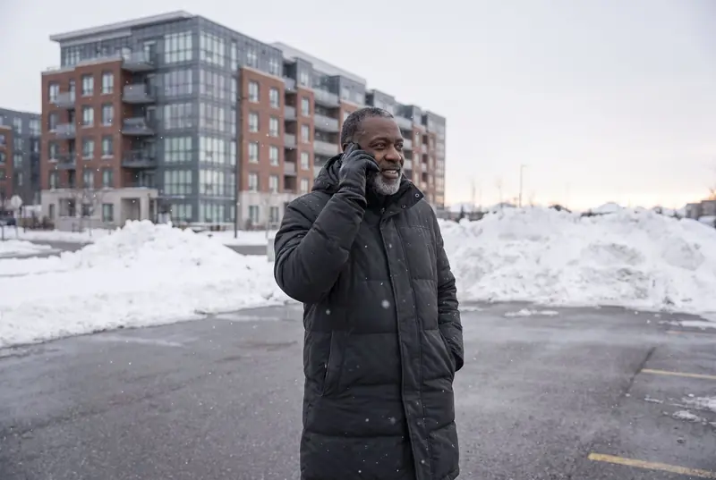 A property manager on his phone in a cleared condo parking lot